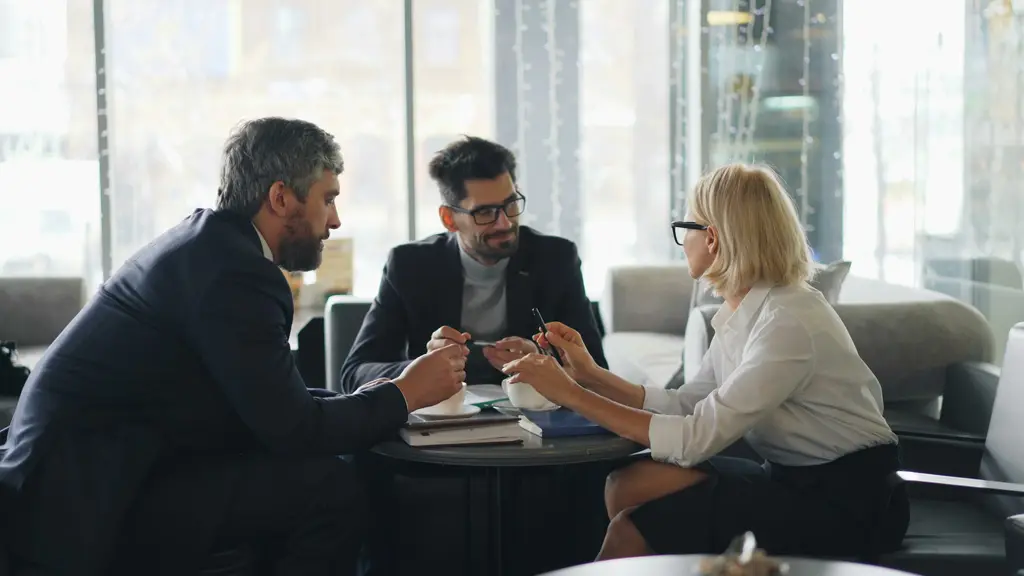 Tres profesionales revisan documentos en una mesa de trabajo