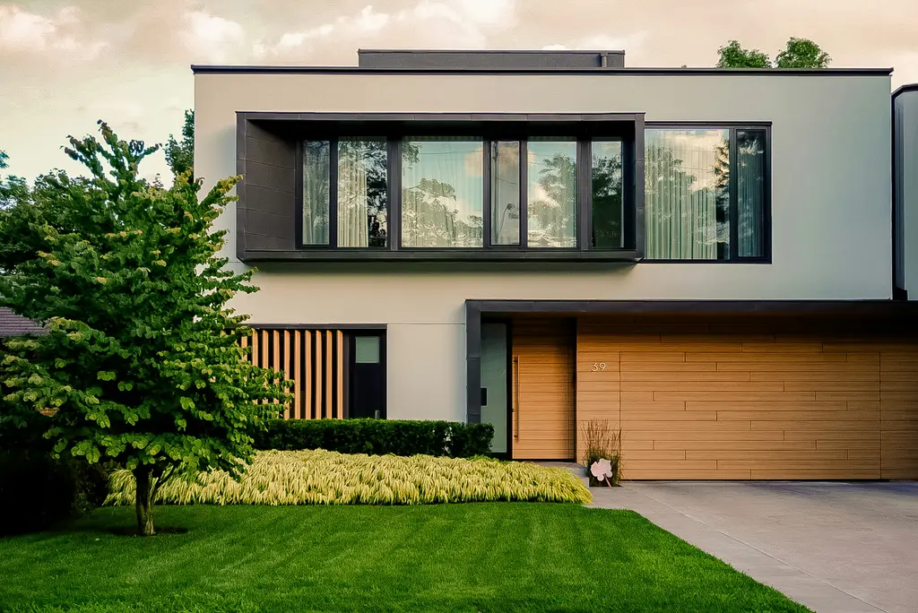 Fachada de una casa contemporánea con jardín y cochera de madera